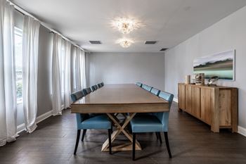 A dining room with a wooden table and blue chairs.